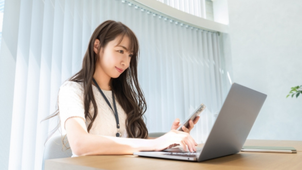 パソコンとスマホを見る女性