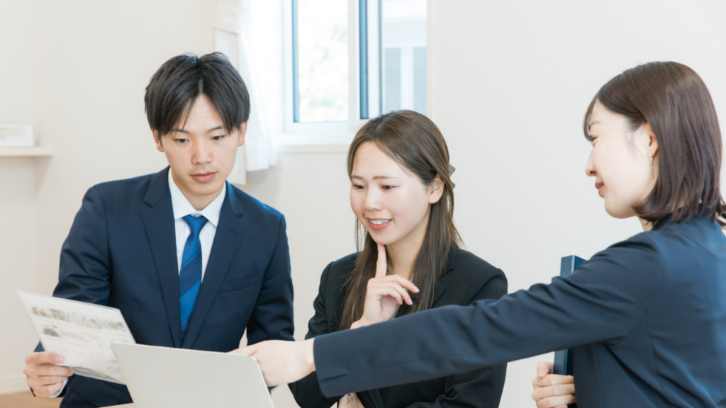 資料やパソコンを見ながら話す男女