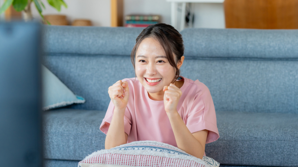テレビの前でガッツポーズする女性