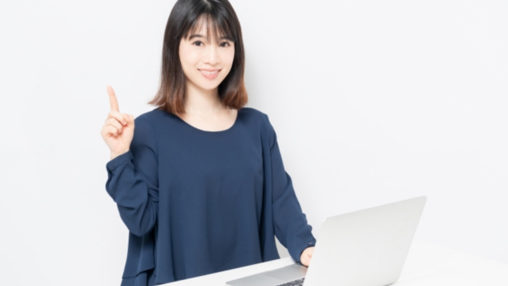 パソコンを前に人差し指を出す女性