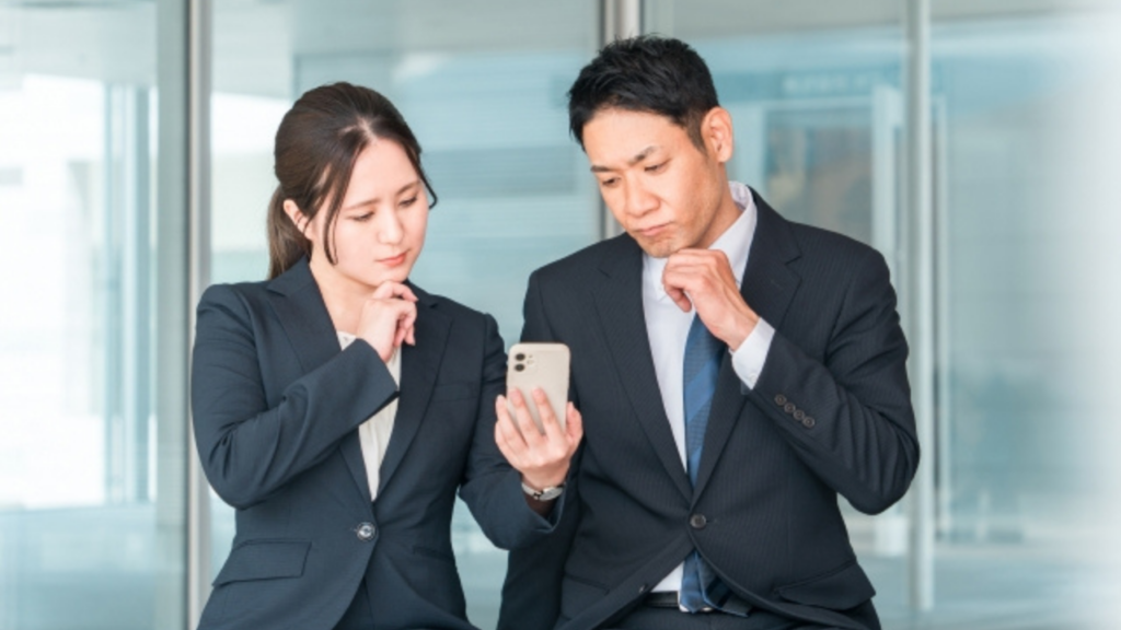 スマホを見て悩む様子の男女2人