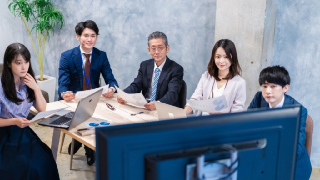 モニターを見ている複数の会社員