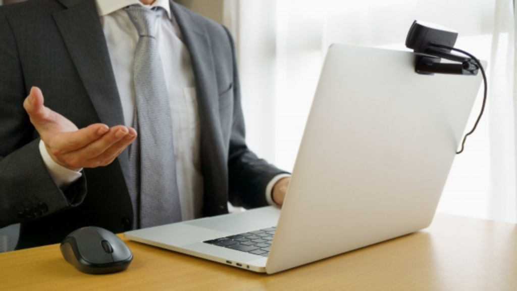 カメラを設置したノートパソコン　身振りをする男性