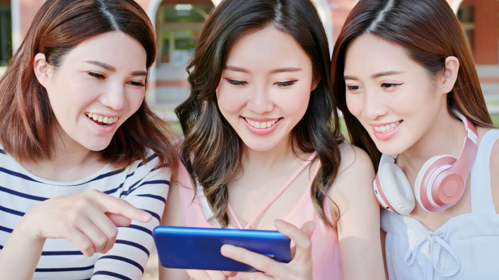スマホをのぞき込む3人の女性