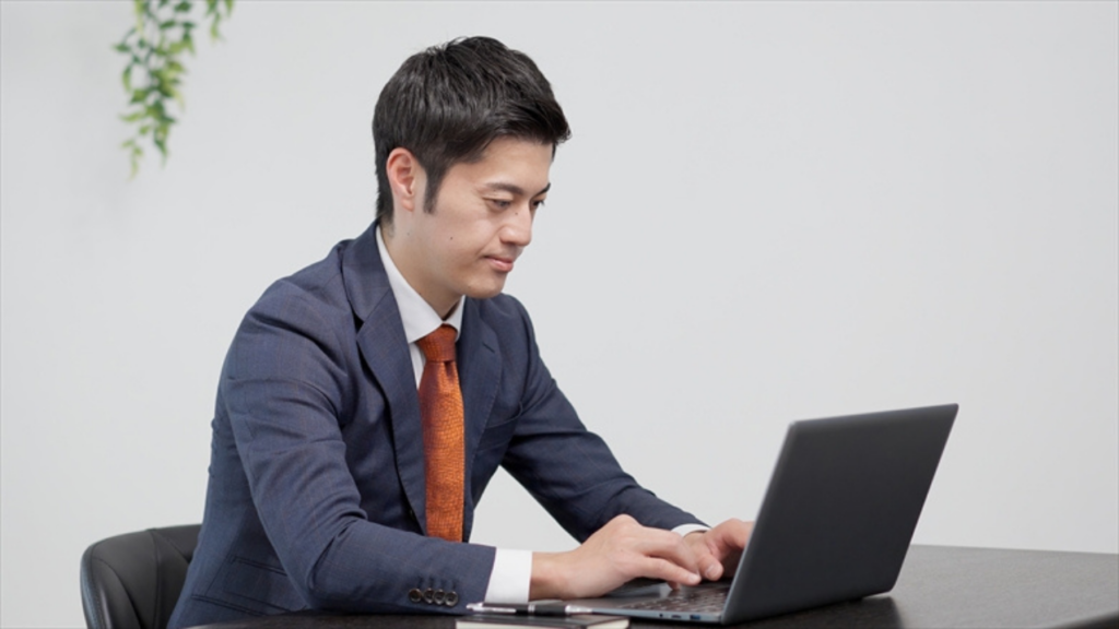 パソコンで作業するスーツの男性