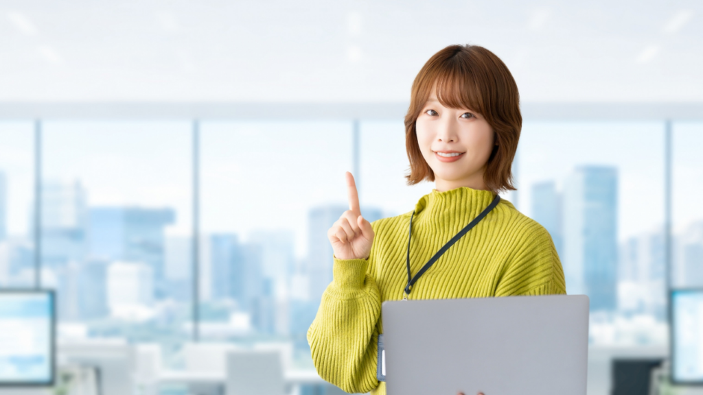 パソコンを片手に人差し指を立てる女性