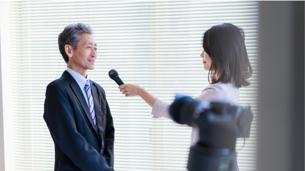 女性がスーツ姿の男性にインタビューする様子