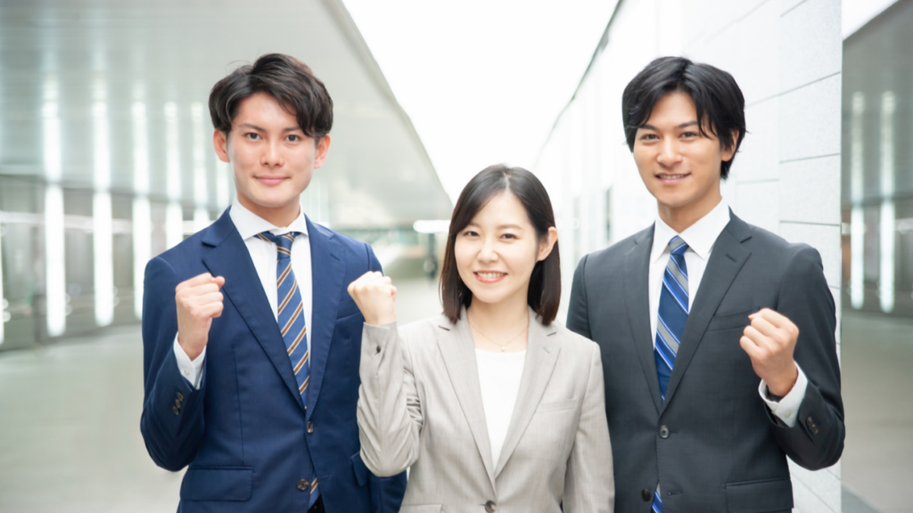 片手でガッツポーズをする男女3人