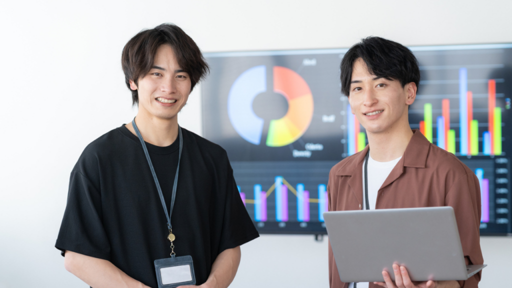 パソコンを片手に持つ男性